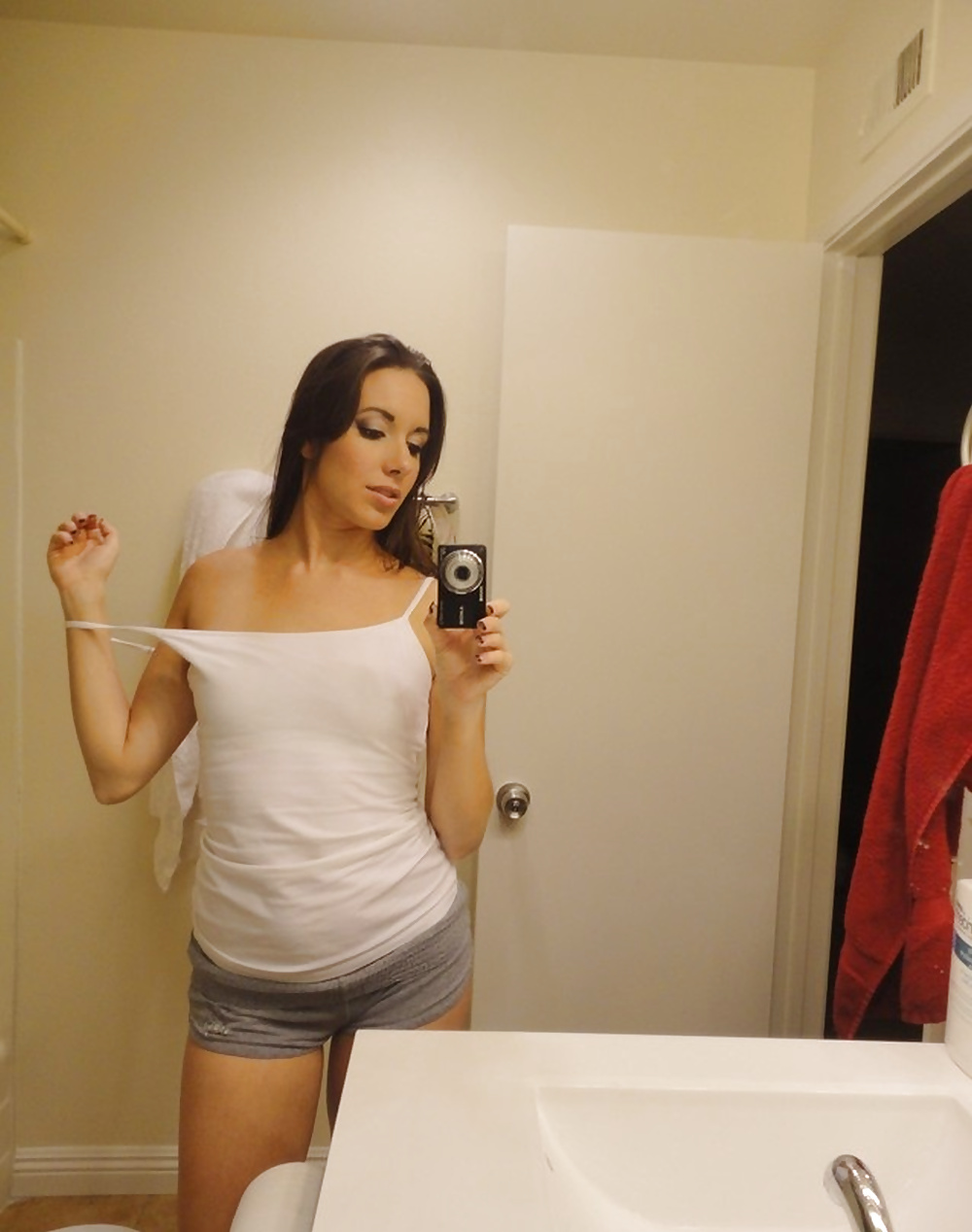 Young bitch in white shirt posing in the mirror porn pictures